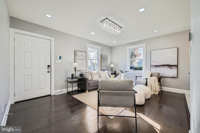 living room with a notable chandelier and dark hardwood / wood-style flooring