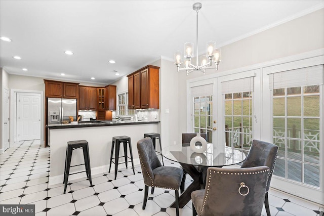 dining space featuring crown molding, french doors, and a chandelier