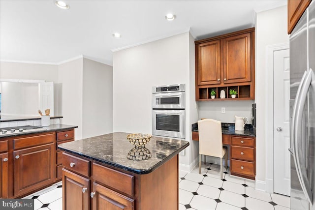 kitchen with ornamental molding, a center island, dark stone counters, and appliances with stainless steel finishes