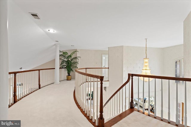 corridor with light carpet and lofted ceiling