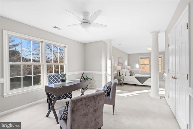 office space featuring a wealth of natural light, light colored carpet, ornate columns, and ceiling fan