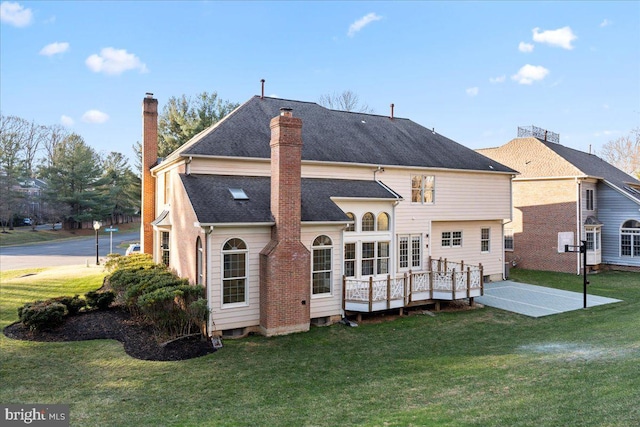 back of house with a lawn, a patio, and a deck