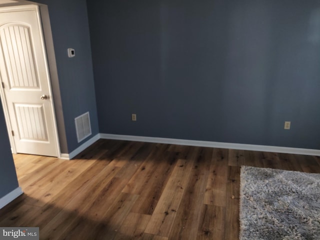 unfurnished room with dark wood-type flooring