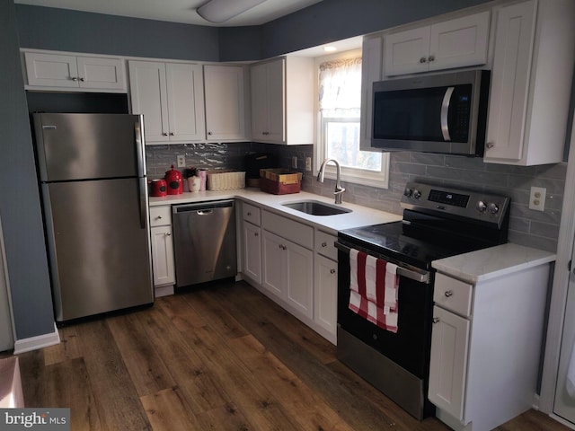 kitchen with white cabinetry, sink, stainless steel appliances, dark hardwood / wood-style floors, and decorative backsplash