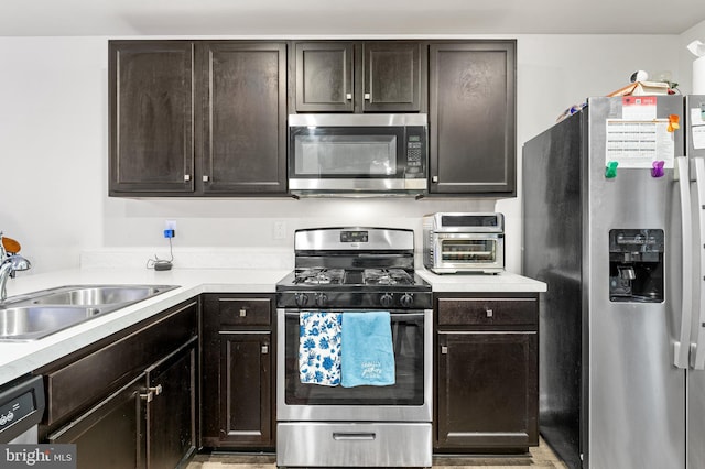 kitchen with dark brown cabinets, sink, and appliances with stainless steel finishes