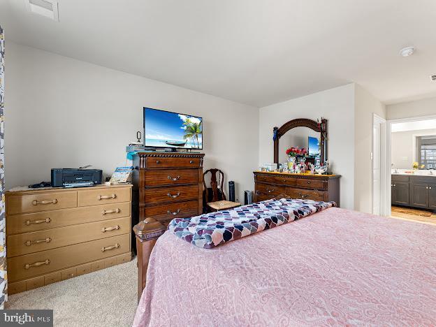 carpeted bedroom featuring ensuite bath