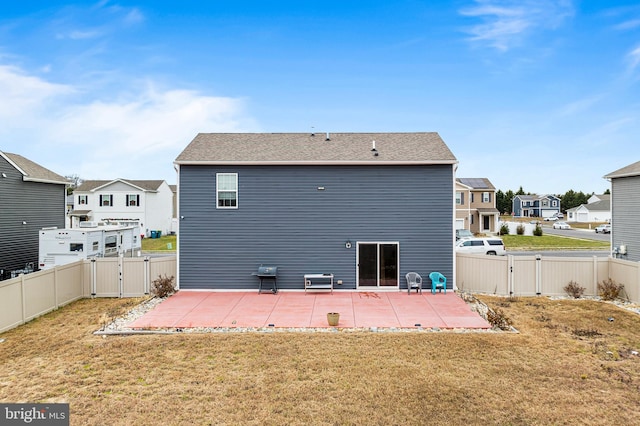 back of house with a yard and a patio