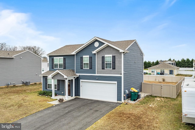 view of property with central air condition unit, a front lawn, and a garage