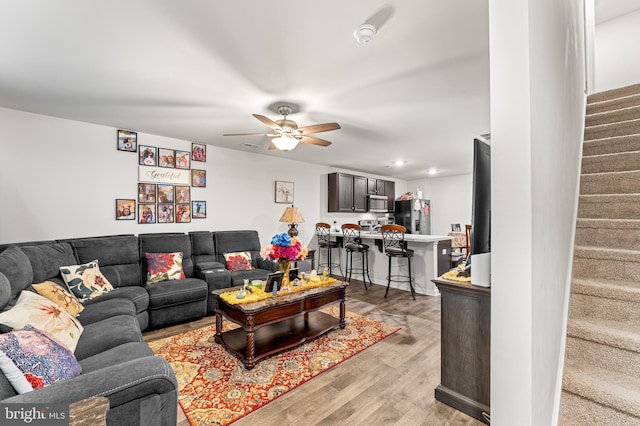 living room featuring light hardwood / wood-style flooring and ceiling fan