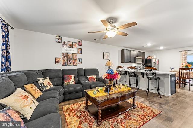 living room with ceiling fan and light hardwood / wood-style floors