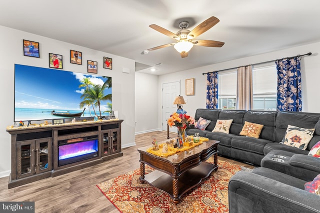 living room with ceiling fan and light hardwood / wood-style flooring