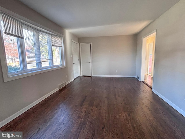 unfurnished room with dark wood-type flooring