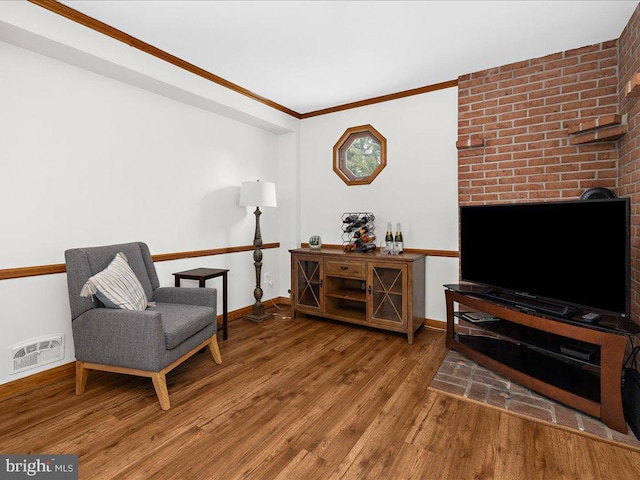 sitting room with wood-type flooring and ornamental molding