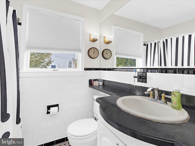 bathroom with vanity, tile walls, and toilet