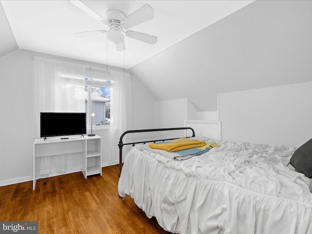 bedroom with hardwood / wood-style flooring, vaulted ceiling, and ceiling fan