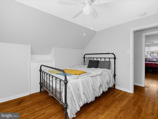 bedroom with ceiling fan, dark hardwood / wood-style floors, and vaulted ceiling