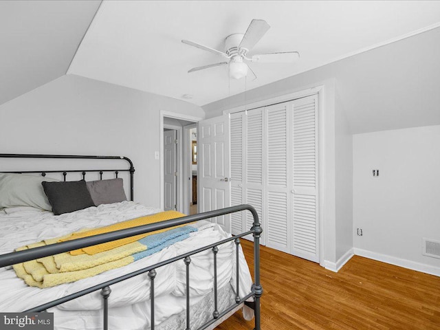 bedroom featuring ceiling fan, a closet, hardwood / wood-style floors, and vaulted ceiling