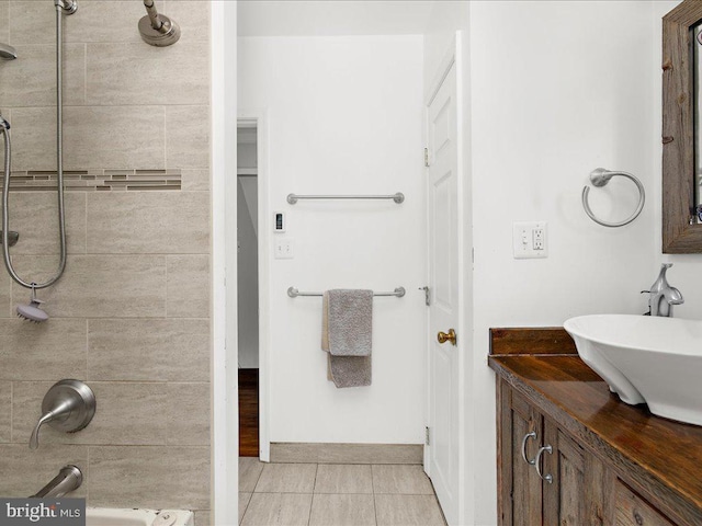 bathroom featuring tile patterned floors, vanity, and a tile shower