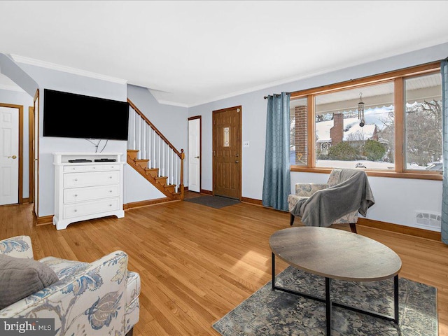 living room with light hardwood / wood-style floors and crown molding