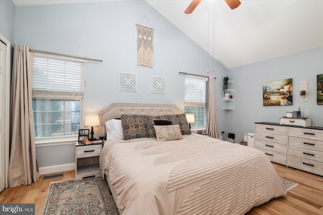 bedroom with ceiling fan, high vaulted ceiling, and light hardwood / wood-style flooring