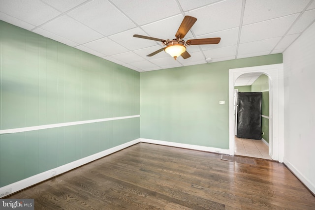 spare room featuring hardwood / wood-style flooring, a paneled ceiling, and ceiling fan