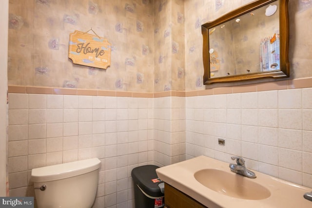 bathroom with vanity, tile walls, and toilet