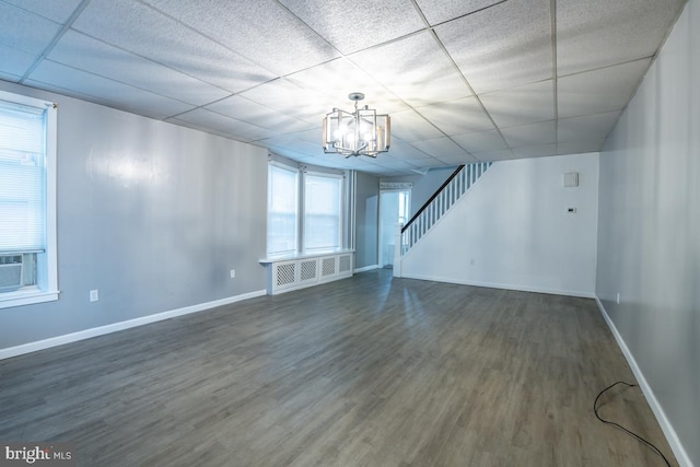 spare room featuring a paneled ceiling, dark hardwood / wood-style floors, radiator, and a notable chandelier