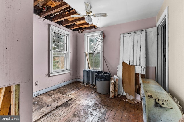 misc room with ceiling fan, dark hardwood / wood-style flooring, and radiator heating unit