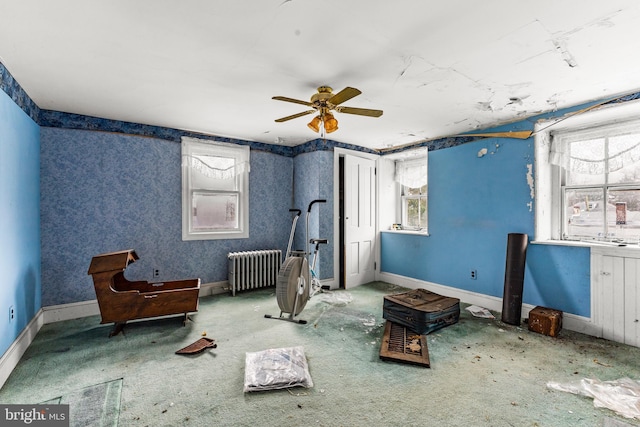 interior space with radiator, ceiling fan, and carpet