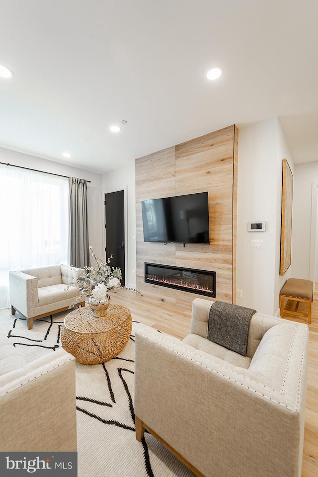 living room with hardwood / wood-style flooring and a large fireplace