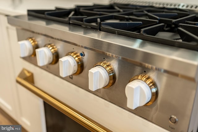 interior details featuring white cabinets and high end stove