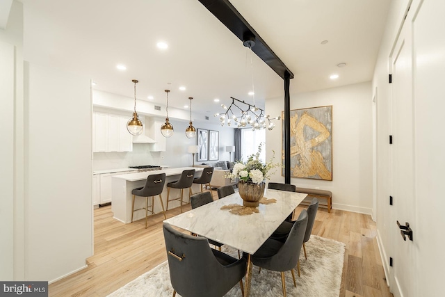 dining area with a notable chandelier and light hardwood / wood-style floors