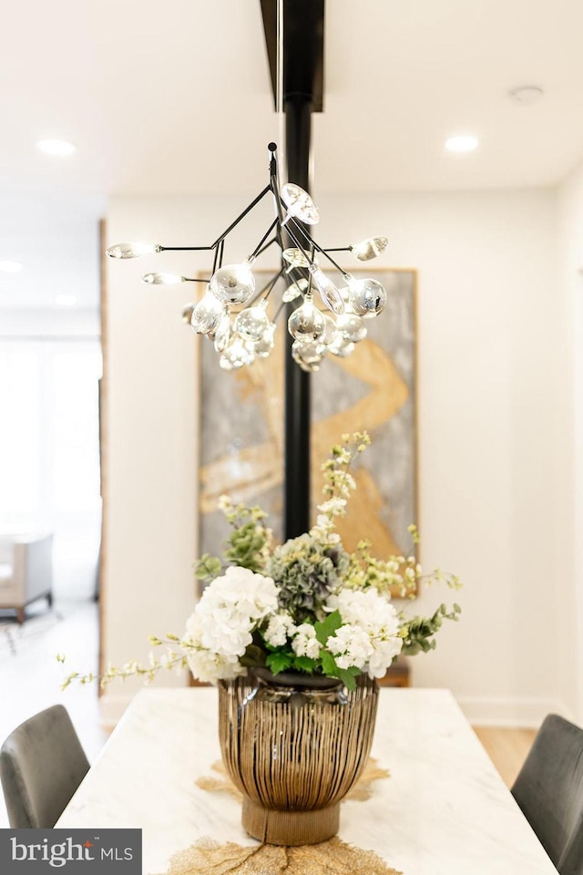 interior details featuring hardwood / wood-style floors and an inviting chandelier