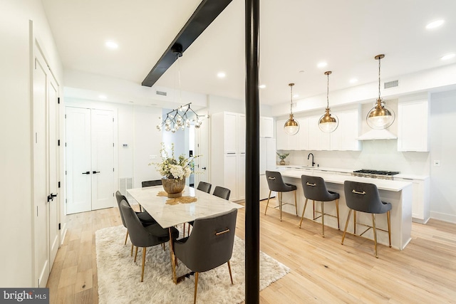 dining space featuring an inviting chandelier and light hardwood / wood-style flooring