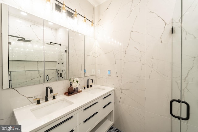 bathroom with vanity, a shower with door, and tile walls