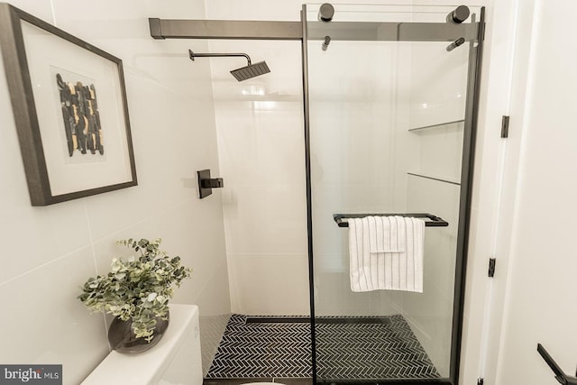 bathroom featuring a shower with shower door and tile walls