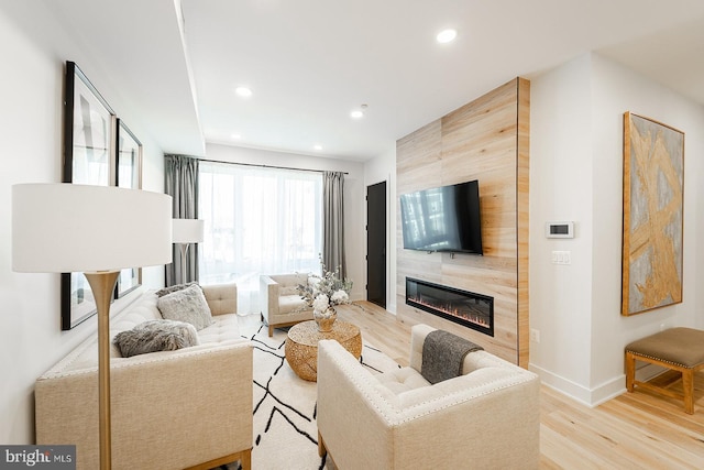 living room featuring light hardwood / wood-style flooring and a tiled fireplace