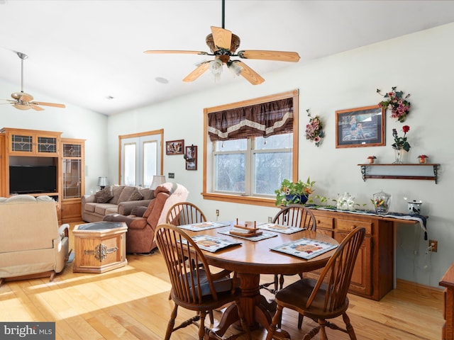 dining room featuring ceiling fan, lofted ceiling, and light hardwood / wood-style flooring