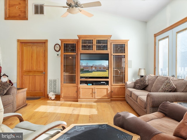 living room with ceiling fan, lofted ceiling, and light wood-type flooring