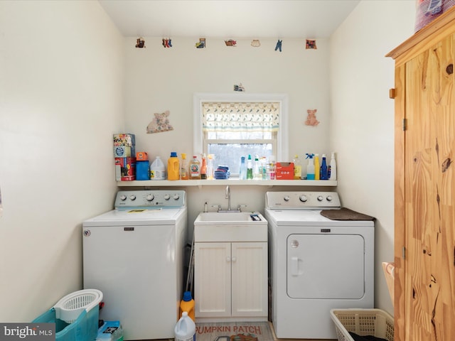 laundry room with cabinets, sink, and washer and dryer