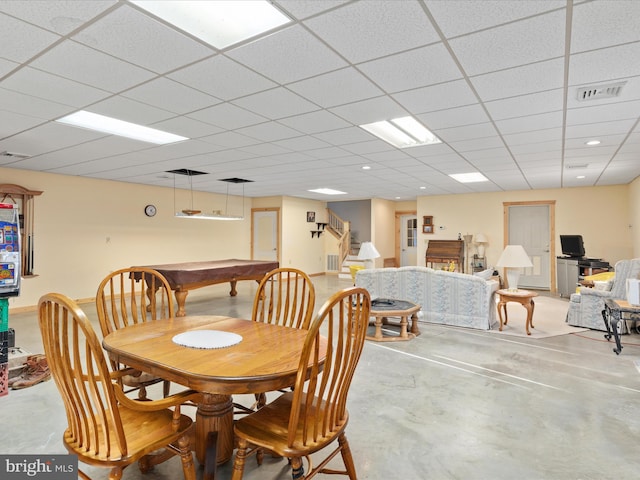 dining space with a paneled ceiling, billiards, and concrete floors