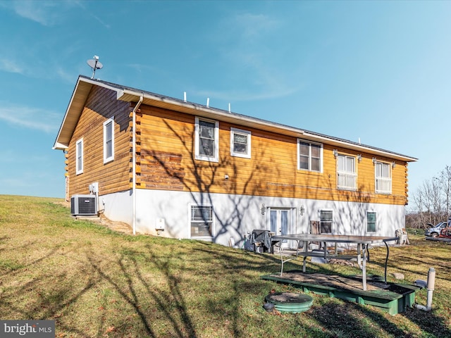 rear view of property with a yard and central AC unit