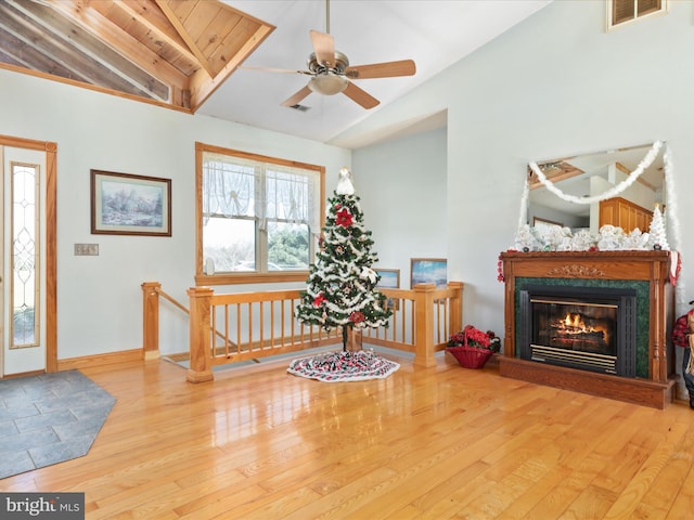 foyer entrance featuring a high end fireplace, lofted ceiling with beams, hardwood / wood-style flooring, and wood ceiling