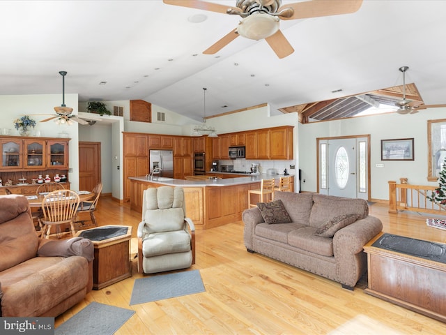 living room with light wood-type flooring and vaulted ceiling