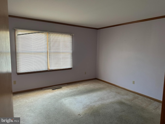 carpeted spare room featuring ornamental molding