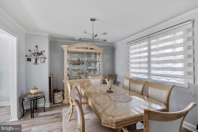 dining area featuring light hardwood / wood-style floors, an inviting chandelier, and ornamental molding