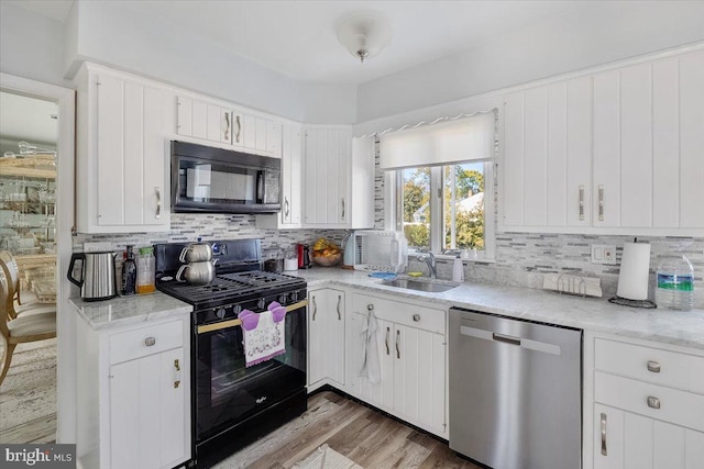 kitchen with black appliances and white cabinetry