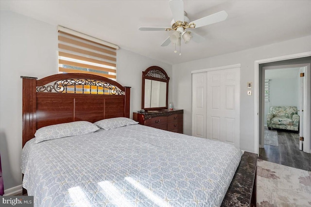 bedroom with ceiling fan, dark wood-type flooring, and a closet