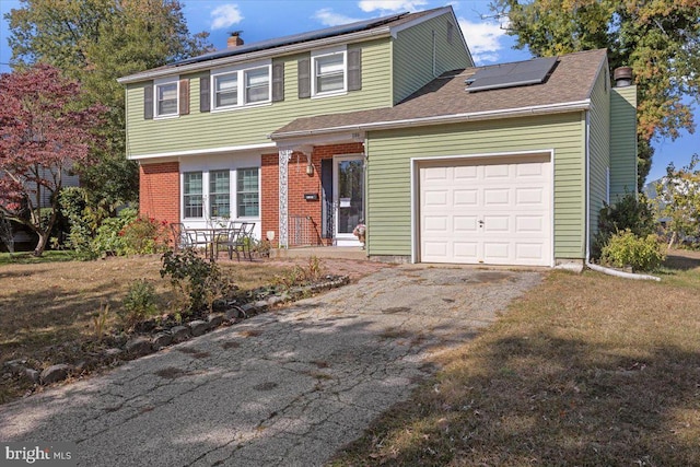 view of front facade featuring solar panels and a garage