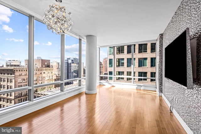 sunroom featuring a healthy amount of sunlight and an inviting chandelier